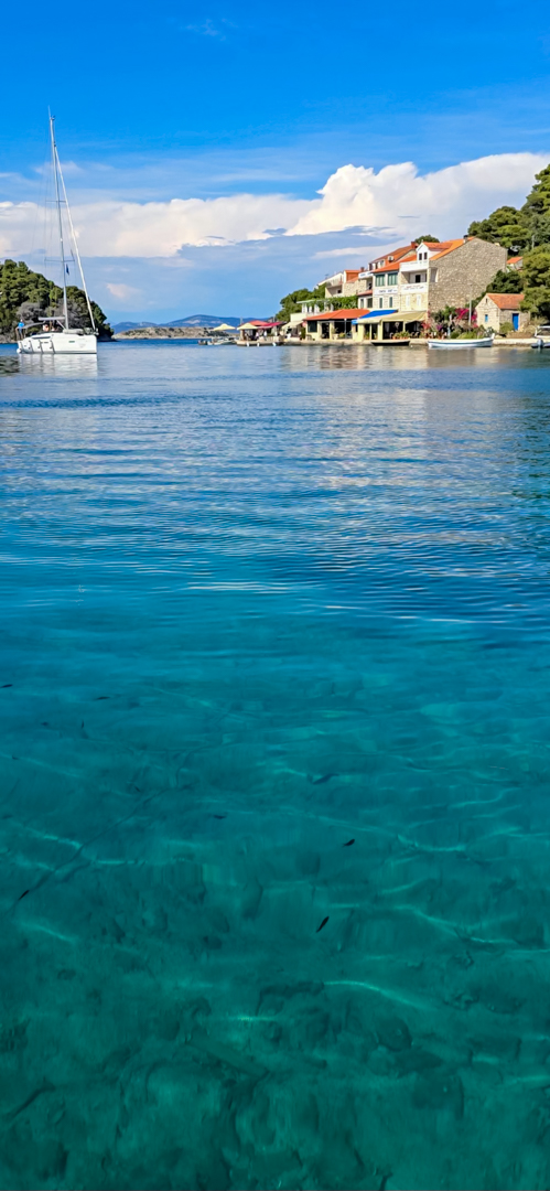 Sailboat on the sea, with crystal clear water.