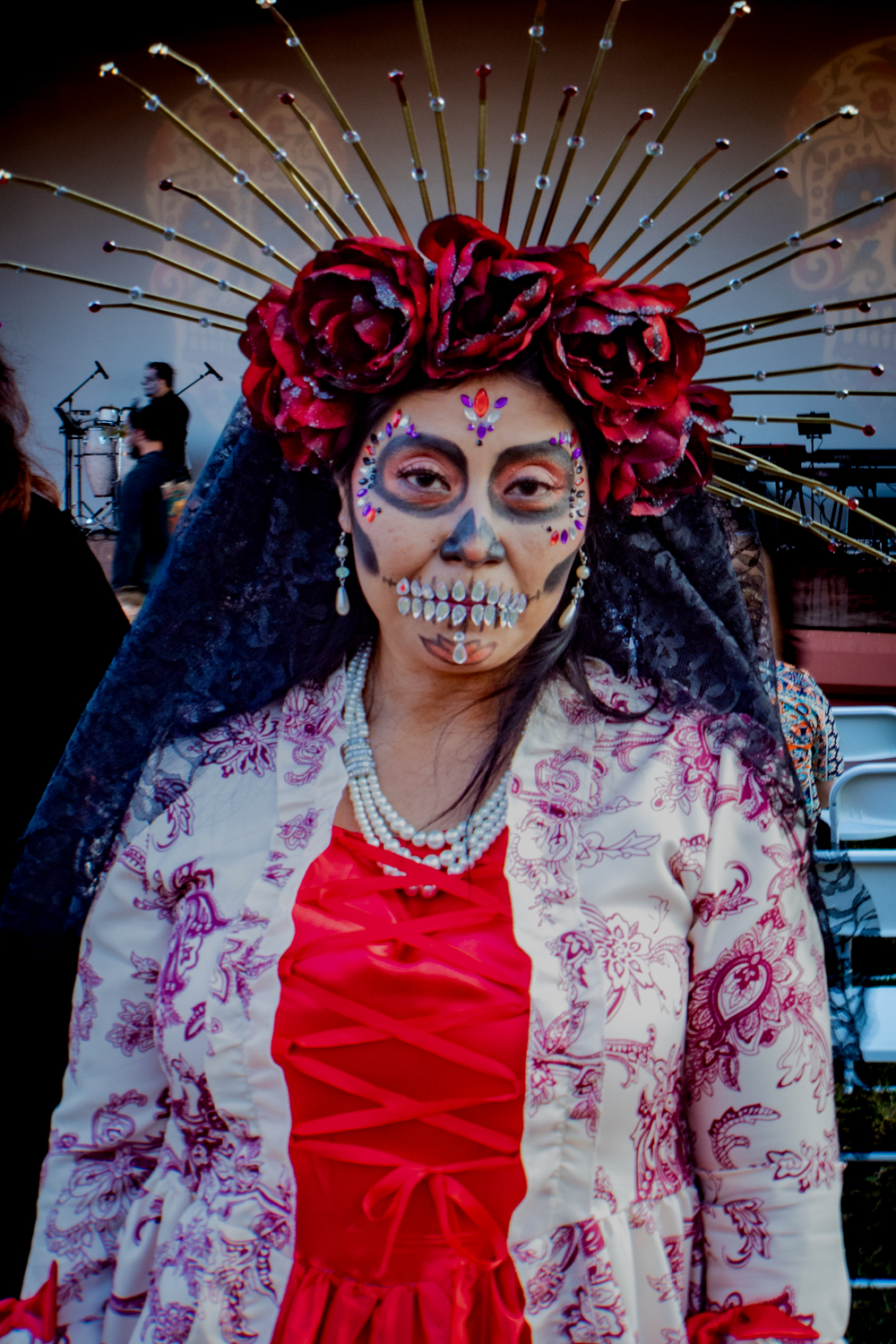 A woman dressed up for the Dia De Los Muertos Festival with face paint.