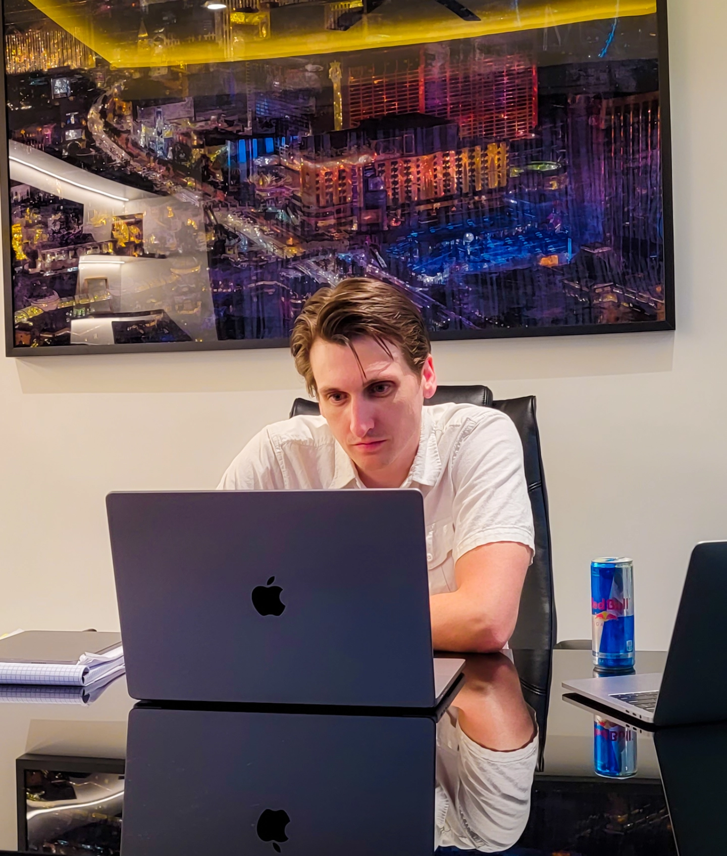 A man sitting at a desk, looking at his laptop