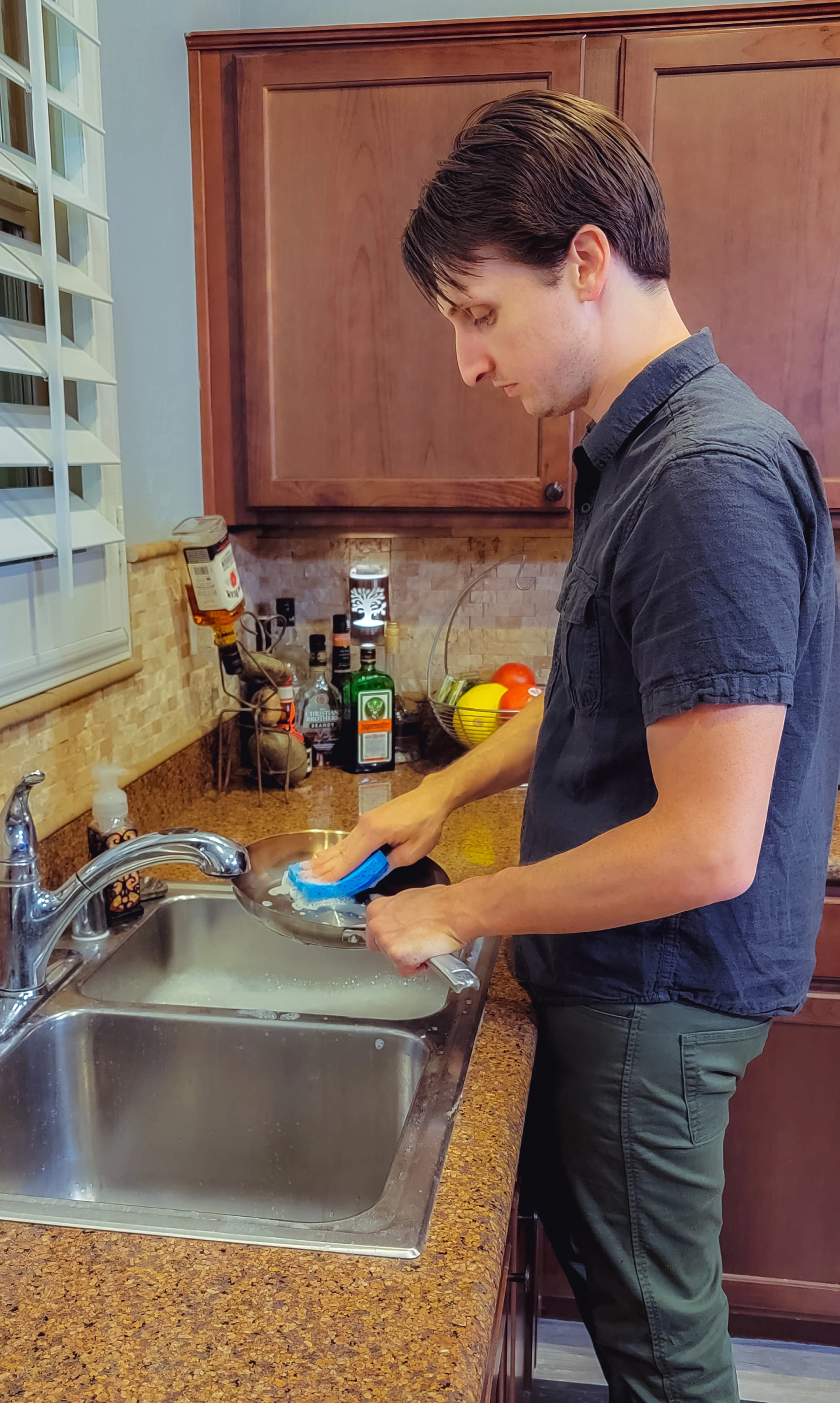 A man washing dishes at the kitchen sink