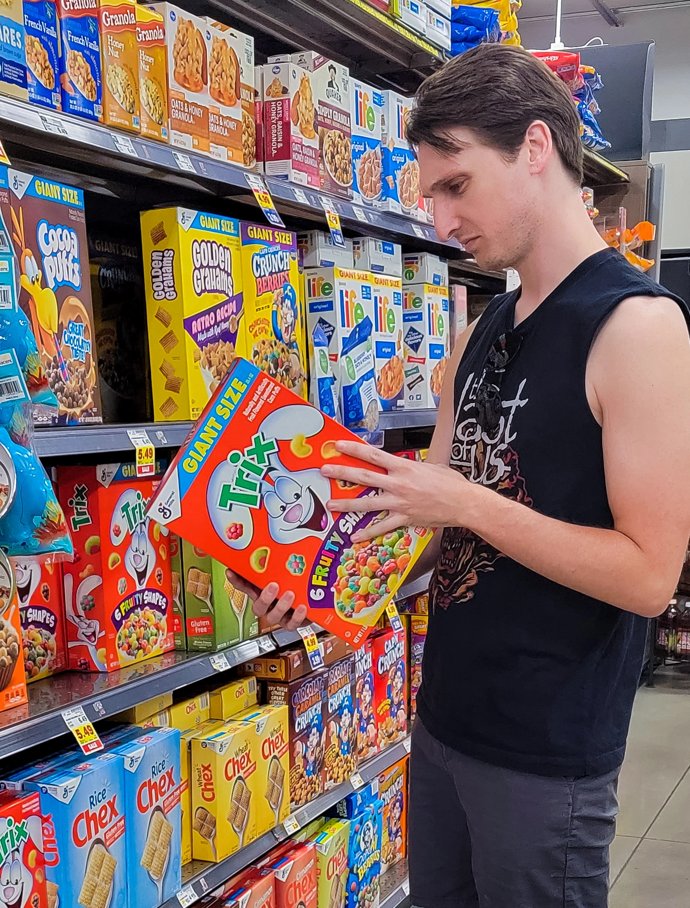 A man inspecting the nutrition facts on a box of cereal at the grocery store